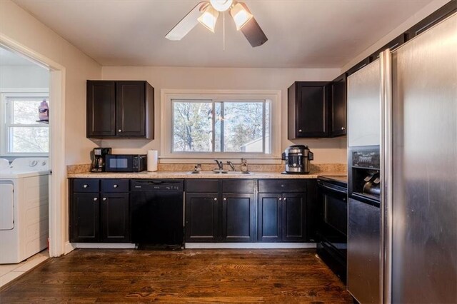 kitchen featuring ceiling fan, sink, separate washer and dryer, dark hardwood / wood-style floors, and black appliances