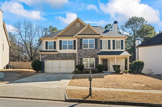 view of front facade featuring driveway, stone siding, a chimney, an attached garage, and fence