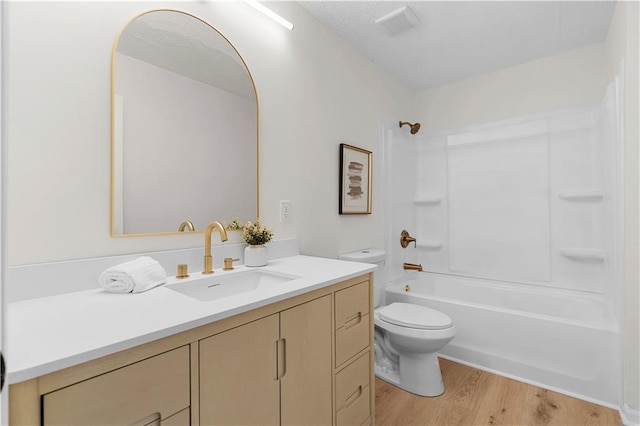 bathroom with  shower combination, vanity, toilet, and wood finished floors