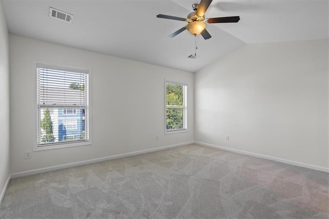 spare room featuring vaulted ceiling, light carpet, and ceiling fan