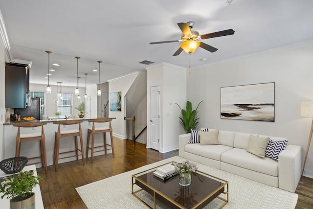 living room with ceiling fan, ornamental molding, and dark hardwood / wood-style flooring