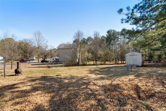 view of yard with an outbuilding, fence, and a storage shed