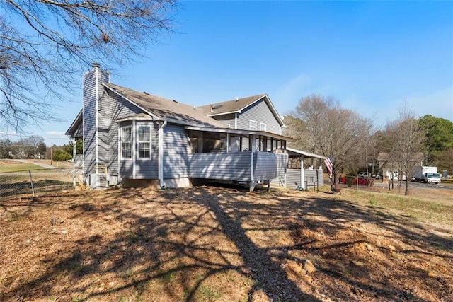 exterior space featuring entry steps, a chimney, and fence