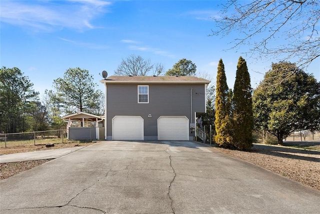 view of side of property featuring a garage, driveway, and fence