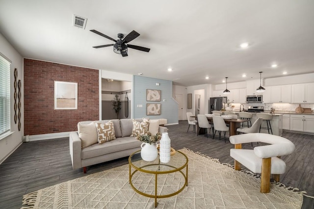 947 Edwin Ln, Sugar Hill, GA 30518 - living room featuring wood finished floors, ceiling fan, recessed lighting, plenty of natural light, and brick wall
