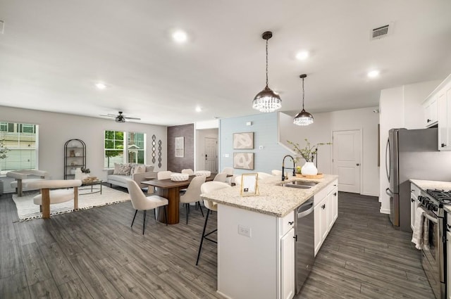 947 Edwin Ln, Sugar Hill, GA 30518 - kitchen with stainless steel appliances, a kitchen bar, white cabinets, an island with sink, and dark wood-style floors