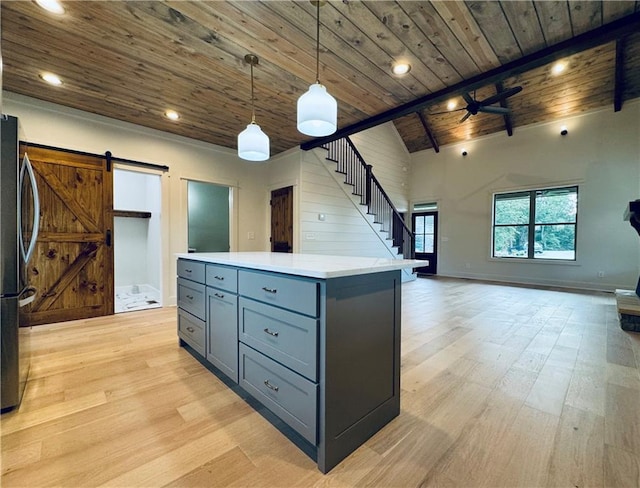 kitchen with light wood-type flooring, wooden ceiling, stainless steel fridge, pendant lighting, and a barn door