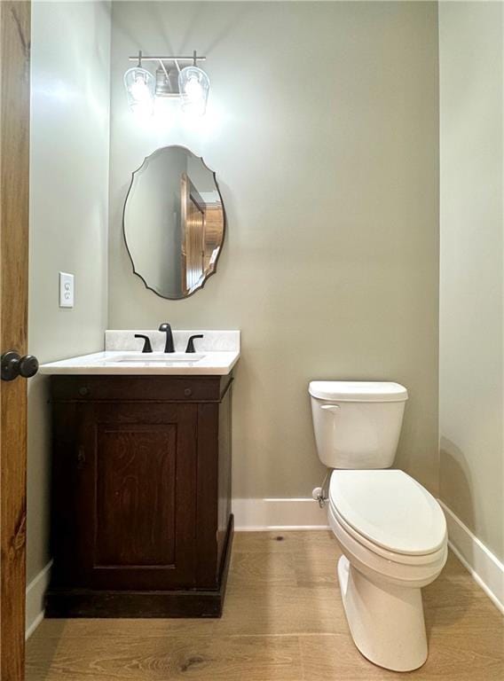 bathroom with vanity, hardwood / wood-style flooring, and toilet