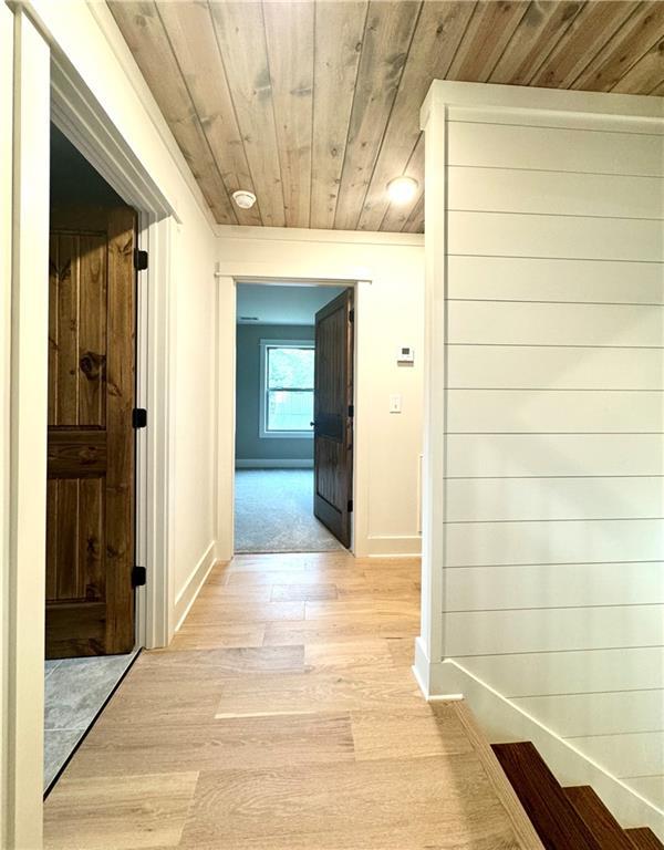 hallway with wood ceiling and light hardwood / wood-style flooring