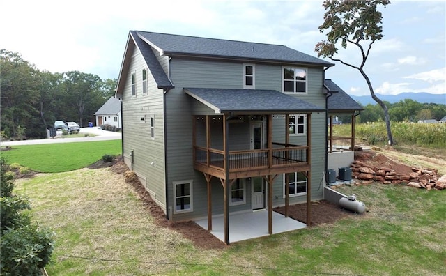 rear view of property featuring a wooden deck, central AC, a patio area, and a lawn