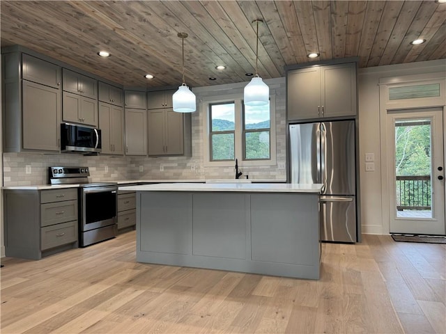 kitchen with pendant lighting, stainless steel appliances, and gray cabinets