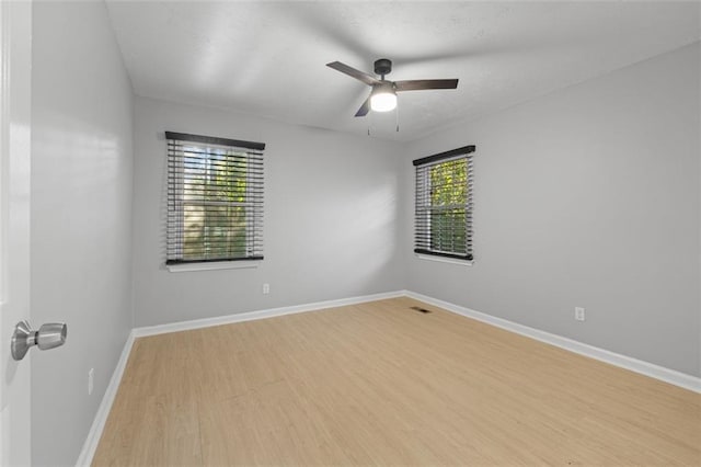 spare room with light hardwood / wood-style floors, plenty of natural light, and ceiling fan