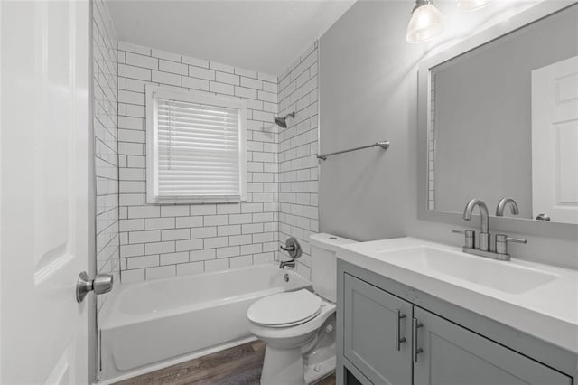 full bathroom featuring vanity, toilet, tiled shower / bath combo, and hardwood / wood-style floors