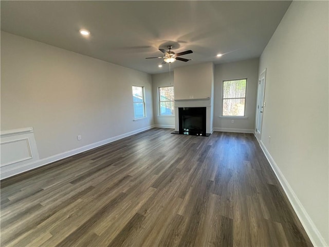 unfurnished living room featuring dark hardwood / wood-style floors and ceiling fan