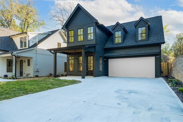 view of front facade featuring a porch, a front lawn, and a garage