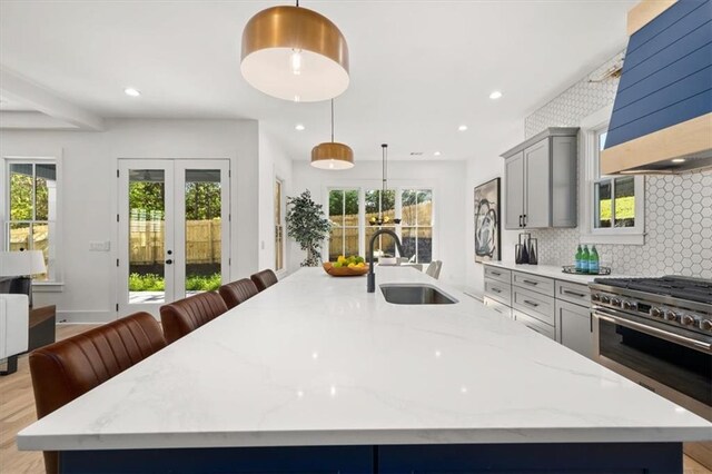 kitchen featuring gray cabinetry, plenty of natural light, and hanging light fixtures