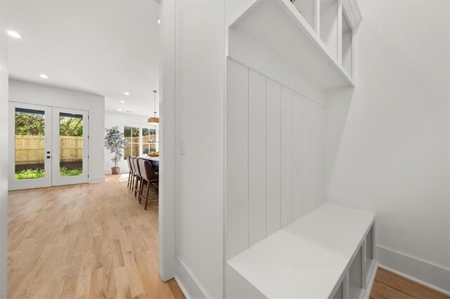 mudroom with french doors and light hardwood / wood-style floors