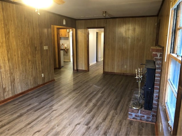 unfurnished living room with crown molding, dark hardwood / wood-style floors, and wood walls