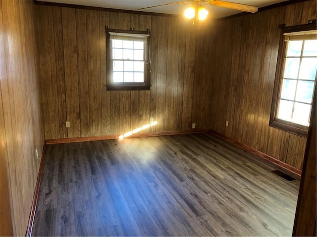 spare room with wooden walls, ceiling fan, and dark hardwood / wood-style flooring