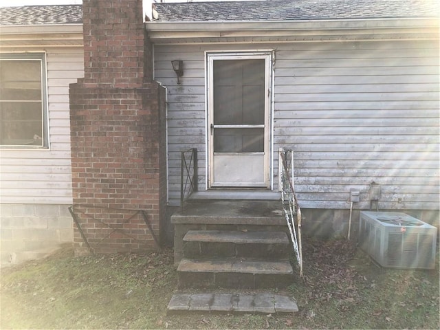 view of exterior entry featuring central air condition unit