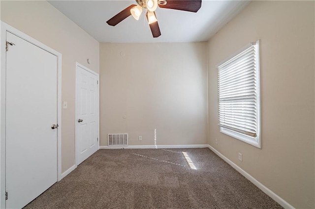 spare room with ceiling fan, carpet, visible vents, and baseboards