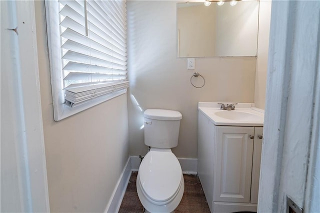 bathroom with toilet, baseboards, and vanity