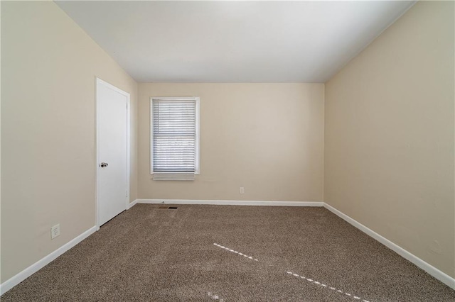 spare room featuring carpet and baseboards