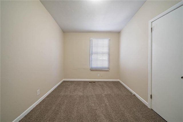 carpeted spare room featuring baseboards