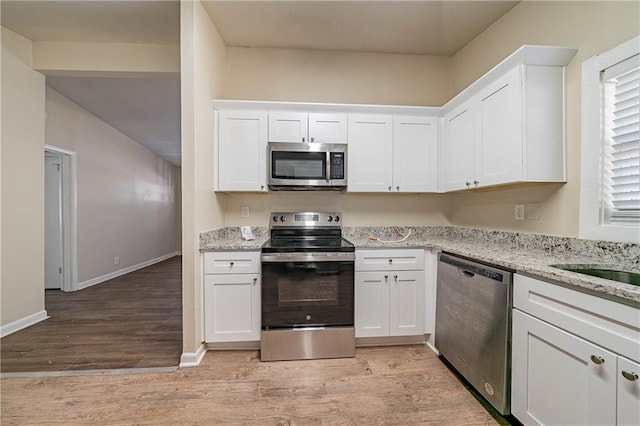 kitchen featuring stainless steel appliances and white cabinetry