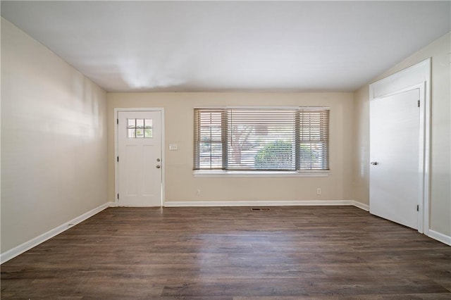 entrance foyer with dark wood-type flooring, a wealth of natural light, and baseboards