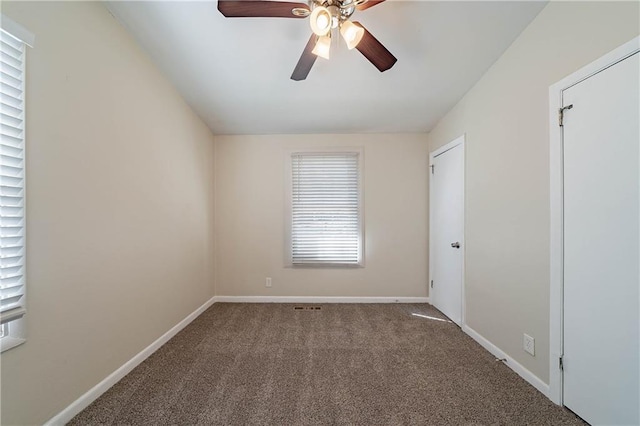 empty room featuring a ceiling fan, carpet, and baseboards