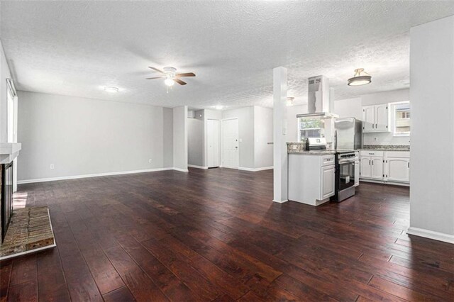 1781 Jajef Ave, Conley, GA 30288 - unfurnished living room featuring a textured ceiling, ceiling fan, a fireplace, dark wood finished floors, and baseboards