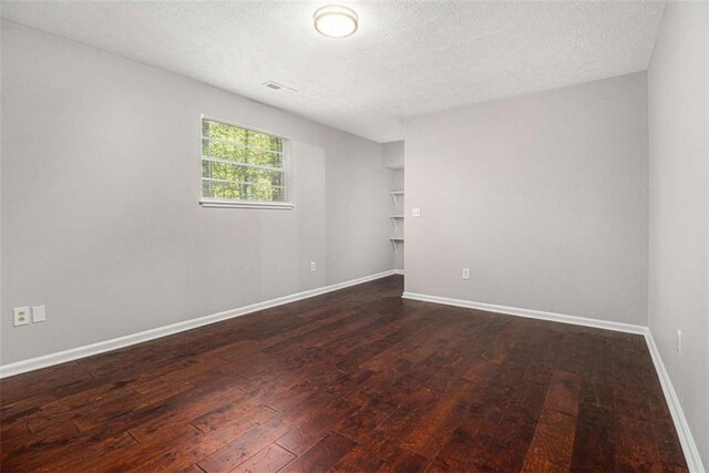 1781 Jajef Ave, Conley, GA 30288 - unfurnished room featuring a textured ceiling, baseboards, and dark wood-style flooring