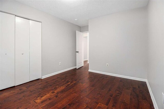1781 Jajef Ave, Conley, GA 30288 - unfurnished bedroom with baseboards, wood finished floors, a textured ceiling, and a closet