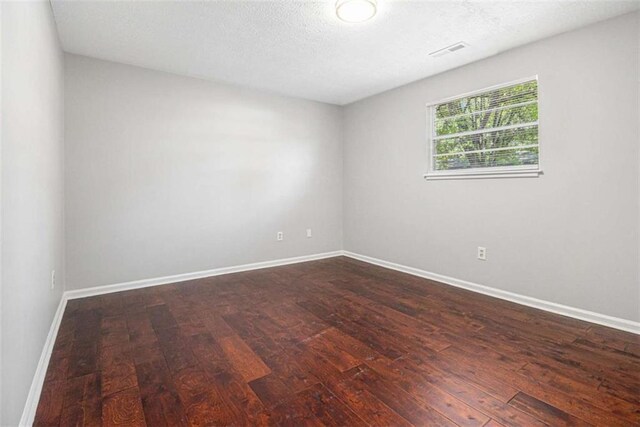 1781 Jajef Ave, Conley, GA 30288 - spare room featuring baseboards, dark wood-type flooring, visible vents, and a textured ceiling
