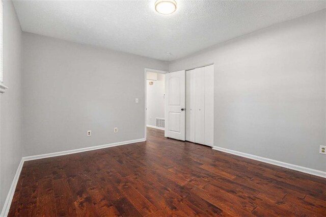 1781 Jajef Ave, Conley, GA 30288 - unfurnished bedroom featuring dark wood-type flooring, a closet, visible vents, and baseboards
