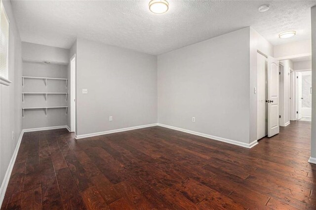 1781 Jajef Ave, Conley, GA 30288 - unfurnished bedroom featuring baseboards, a textured ceiling, and dark wood-type flooring