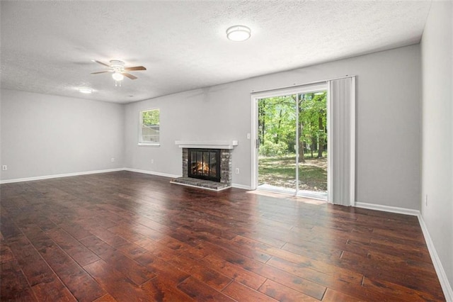 1781 Jajef Ave, Conley, GA 30288 - unfurnished living room with wood-type flooring, a brick fireplace, a textured ceiling, and ceiling fan