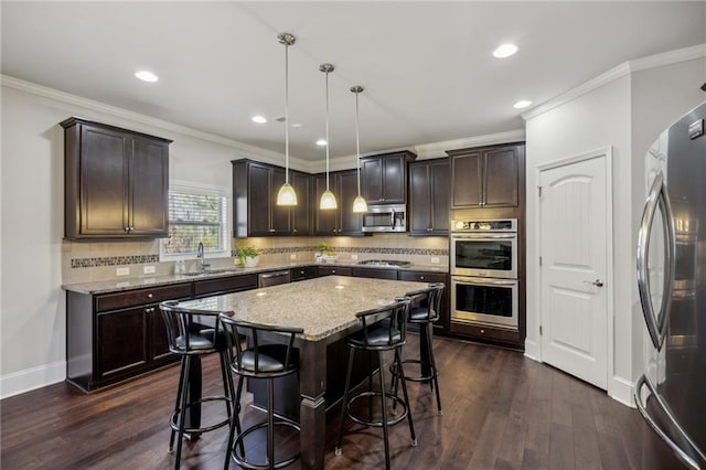 3610 Ansley Manor Ct, Cumming, GA 30028 - kitchen featuring stainless steel appliances, dark brown cabinetry, a kitchen bar, a kitchen island, and recessed lighting