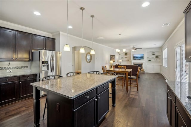 3610 Ansley Manor Ct, Cumming, GA 30028 - kitchen featuring a kitchen bar, a ceiling fan, dark wood-style floors, arched walkways, and open floor plan