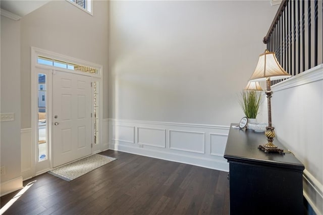 3610 Ansley Manor Ct, Cumming, GA 30028 - foyer entrance featuring a wainscoted wall, dark wood-style flooring, a high ceiling, and a decorative wall