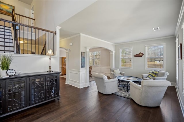 3610 Ansley Manor Ct, Cumming, GA 30028 - living area with ornate columns, dark wood-type flooring, arched walkways, ornamental molding, and a wainscoted wall