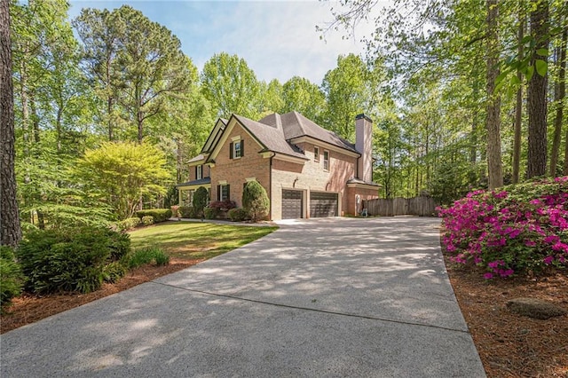 125 Hopewell Grove Dr, Milton, GA 30004 - view of front facade featuring brick siding, concrete driveway, a garage, and a chimney