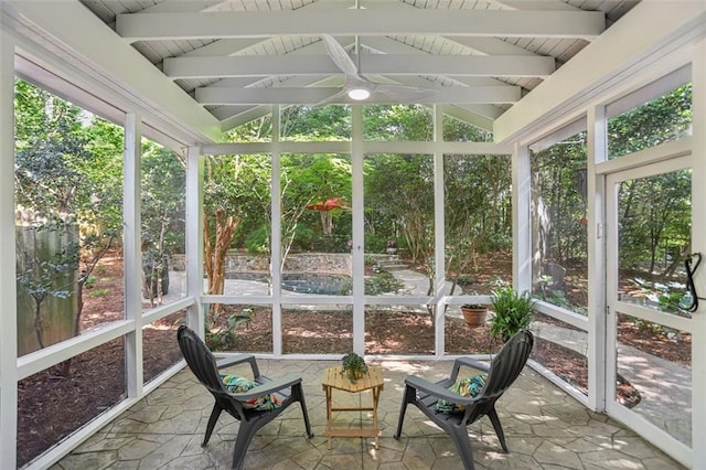 sunroom / solarium with a wealth of natural light, beamed ceiling, and ceiling fan