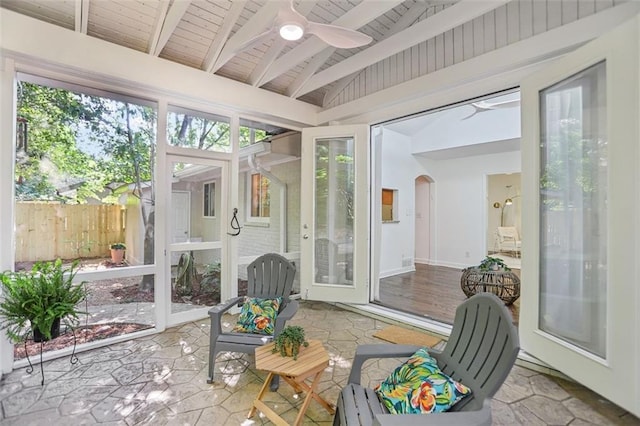 sunroom / solarium featuring ceiling fan, beamed ceiling, and arched walkways