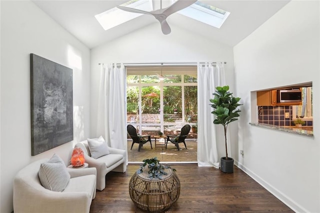 living area with dark wood finished floors, a skylight, ceiling fan, and high vaulted ceiling