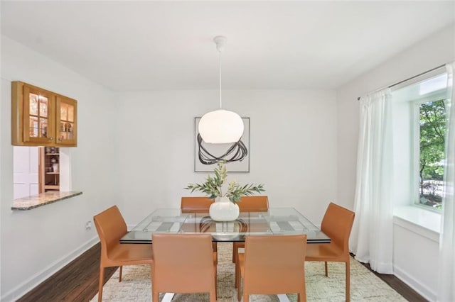 dining area featuring baseboards and wood finished floors