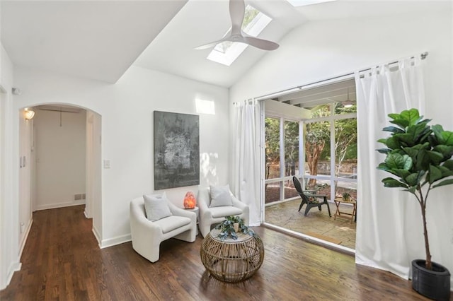 living area featuring a skylight, arched walkways, a ceiling fan, and wood finished floors