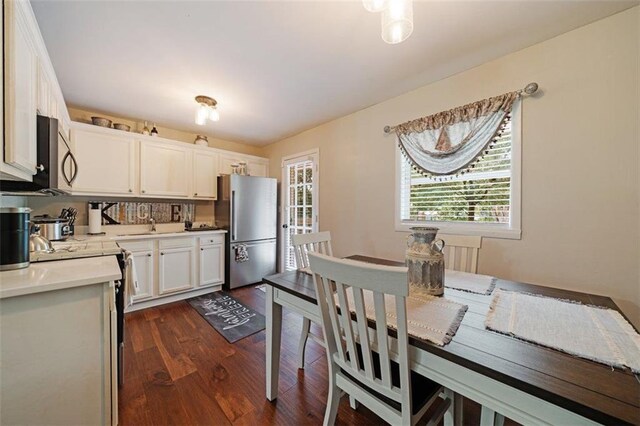 57 Jonathan Rd, Riverdale, GA 30274 - kitchen with appliances with stainless steel finishes, light countertops, dark wood-style floors, and white cabinetry