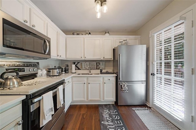57 Jonathan Rd, Riverdale, GA 30274 - kitchen featuring appliances with stainless steel finishes, a sink, light countertops, dark wood-style flooring, and white cabinets